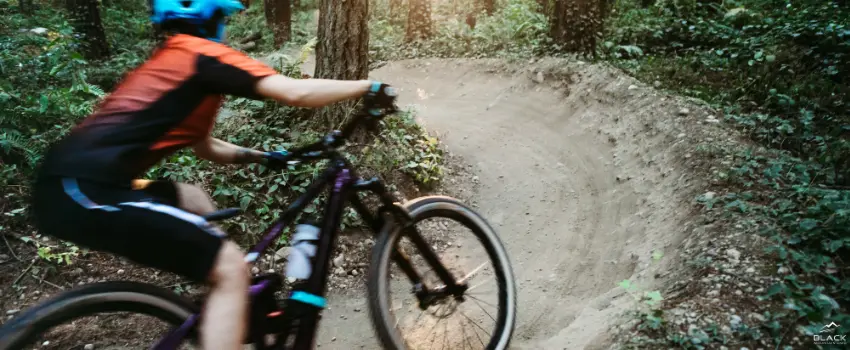 BML-A woman riding a bike along a mountain trail