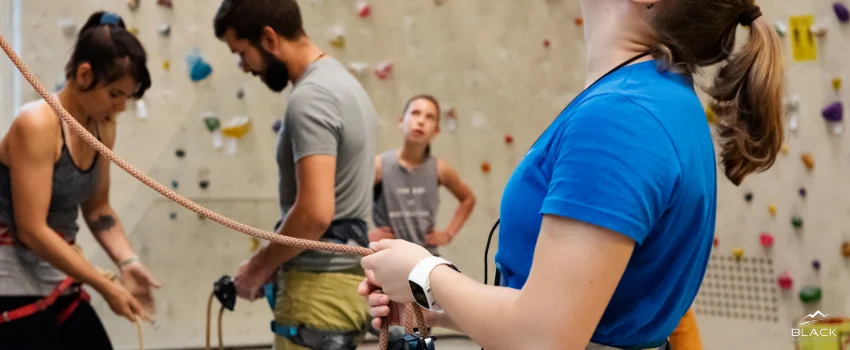 A woman checks the safety harness and rope before the rock climbing activities.