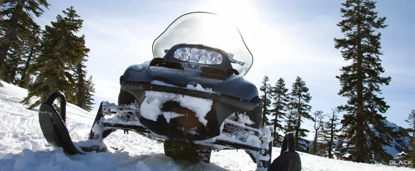 Snowmobile on a snowy mountain slope.