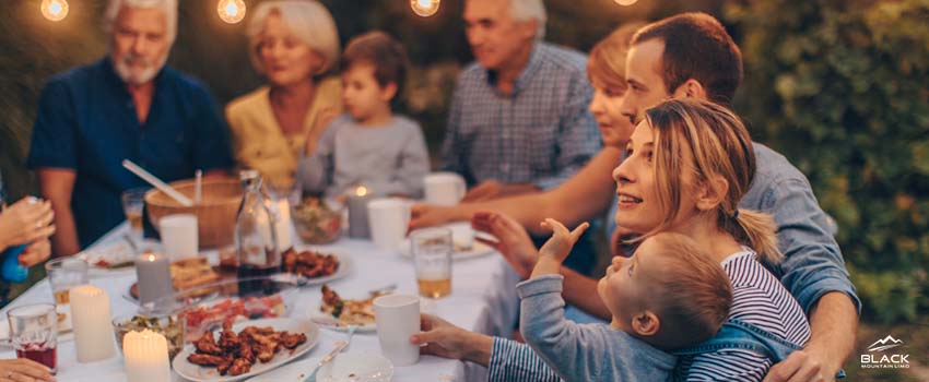 Family gathering together for dinner.