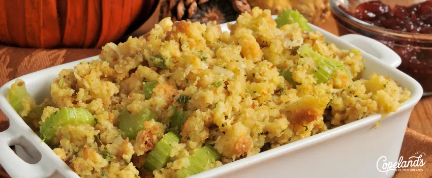 COJ - A casserole of cornbread stuffing on a wooden table